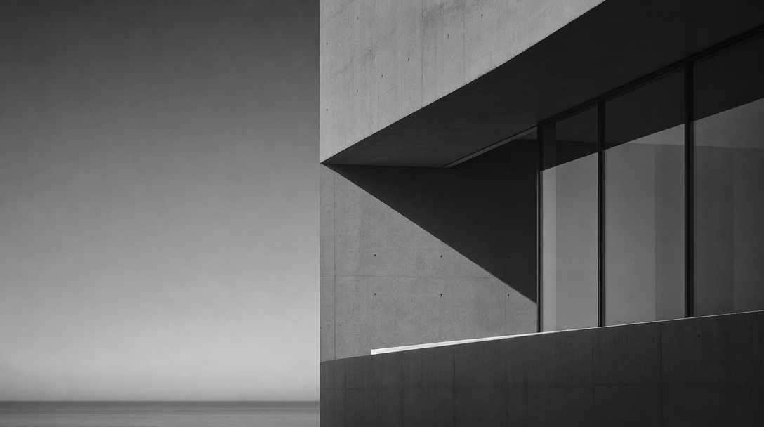 Abstrakte Architekturaufnahme: Betonfassade mit Glasfront im Streiflicht, Meer im Hintergrund